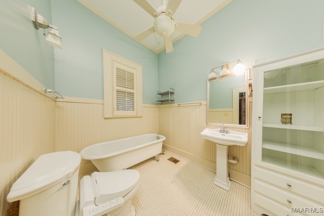 bathroom featuring ceiling fan, sink, a tub, tile patterned floors, and toilet