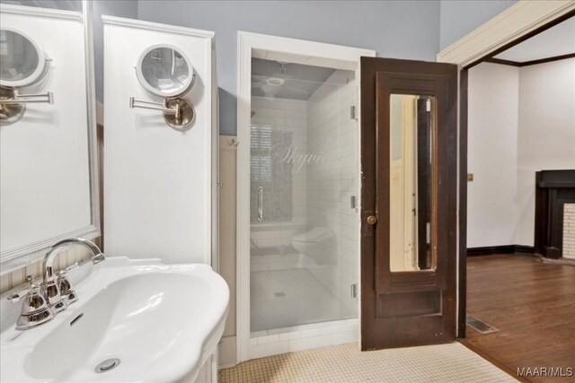 1311 Woodward Ave, Montgomery, AL 36106 - bathroom with a sink, a shower stall, and wood finished floors