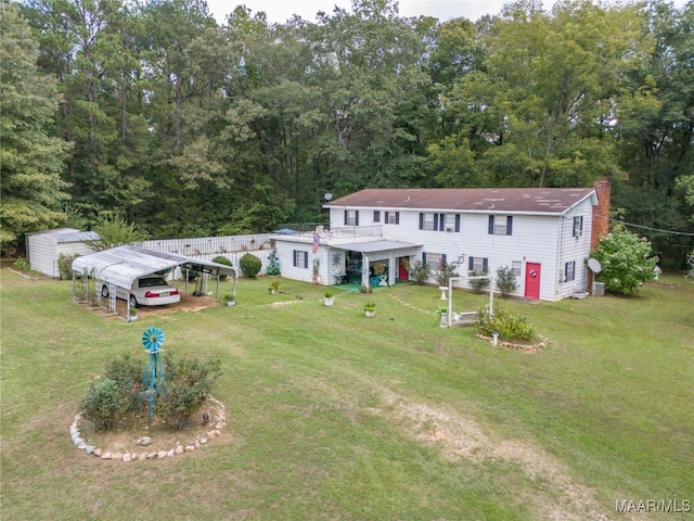 view of front facade featuring a carport, a storage unit, and a front yard