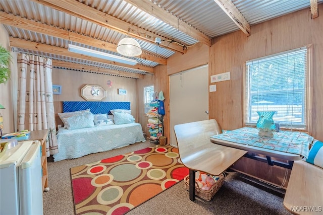 bedroom featuring wood walls, beam ceiling, carpet floors, and a closet