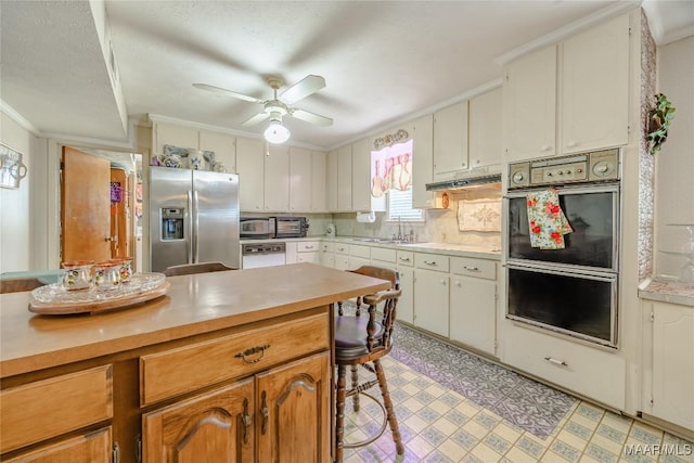 kitchen featuring stainless steel fridge, crown molding, white cabinets, and ceiling fan