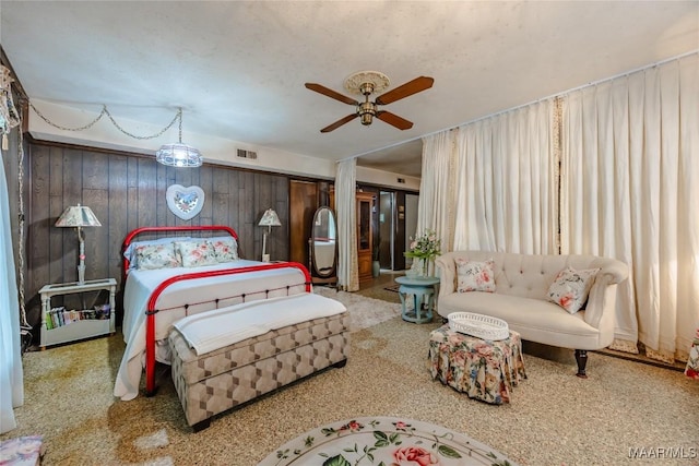 bedroom featuring a closet, ceiling fan, and wood walls