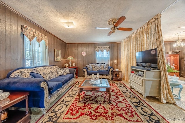 living room featuring ceiling fan with notable chandelier, carpet, a textured ceiling, and wood walls