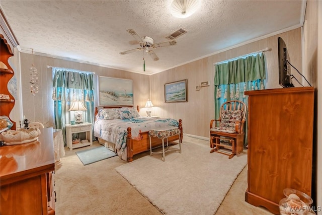 bedroom featuring ceiling fan, crown molding, light carpet, and a textured ceiling