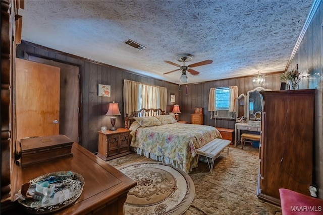 bedroom with carpet flooring, a textured ceiling, ceiling fan with notable chandelier, and crown molding