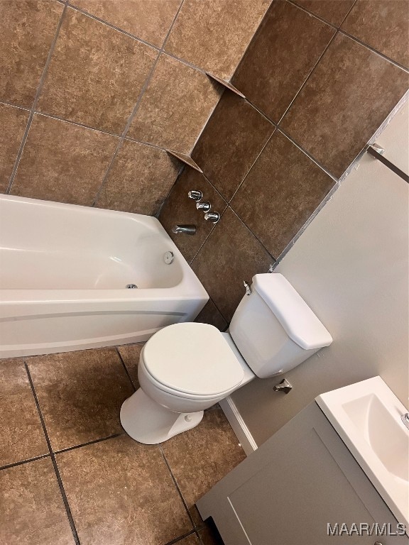 bathroom with a bathing tub, toilet, vanity, and tile patterned floors