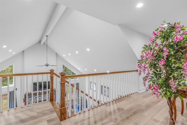 hallway with high vaulted ceiling, beam ceiling, light hardwood / wood-style floors, and plenty of natural light