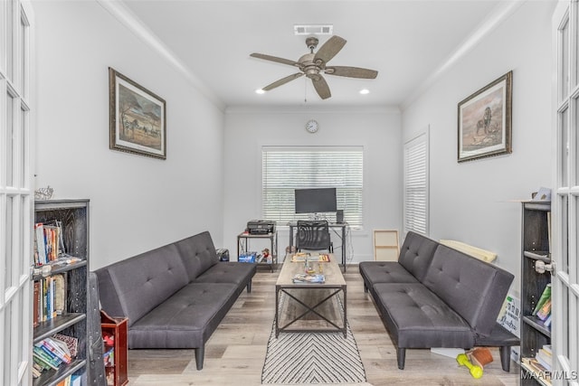 living room with light hardwood / wood-style flooring, ceiling fan, a healthy amount of sunlight, and crown molding