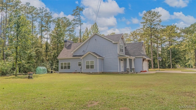 rear view of property featuring a lawn