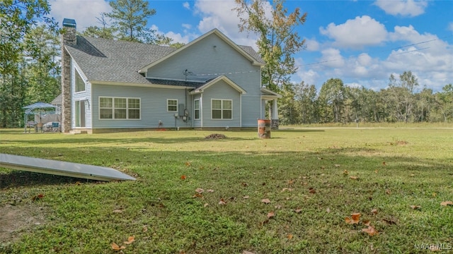 back of property with a gazebo and a yard