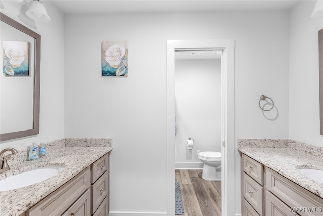 bathroom featuring hardwood / wood-style floors, vanity, and toilet