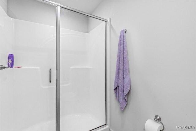 bathroom featuring a shower with door