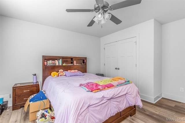 bedroom featuring light hardwood / wood-style floors, ceiling fan, and a closet