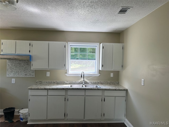 kitchen featuring a textured ceiling, white cabinetry, sink, and dark hardwood / wood-style flooring