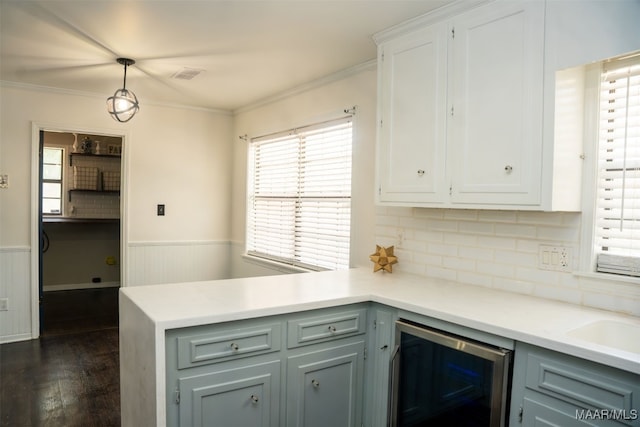 kitchen with wine cooler, dark wood-type flooring, hanging light fixtures, decorative backsplash, and crown molding