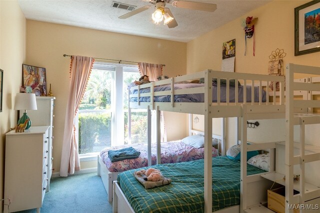 bedroom featuring a textured ceiling, ceiling fan, and light colored carpet