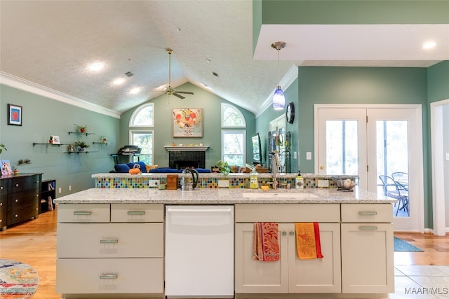 kitchen featuring white cabinets, sink, ornamental molding, dishwasher, and light wood-type flooring