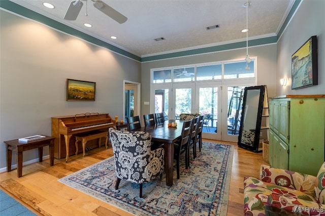 dining room featuring ornamental molding, ceiling fan, french doors, and light hardwood / wood-style flooring