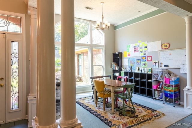 carpeted dining area with ornate columns, ornamental molding, a notable chandelier, and a textured ceiling