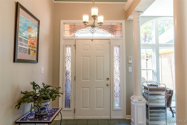 foyer with ornate columns, ornamental molding, and a chandelier