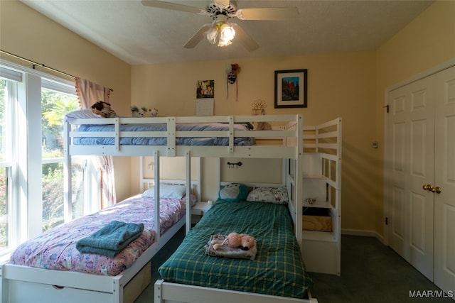 bedroom featuring ceiling fan, carpet floors, a closet, and a textured ceiling