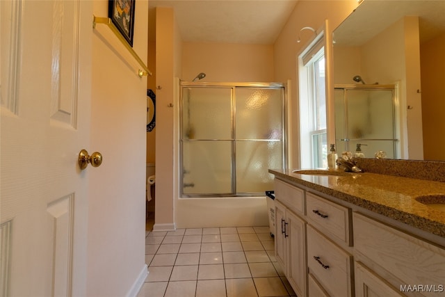 bathroom featuring bath / shower combo with glass door, vanity, and tile patterned flooring