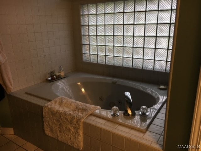 bathroom with tile patterned flooring and a relaxing tiled tub