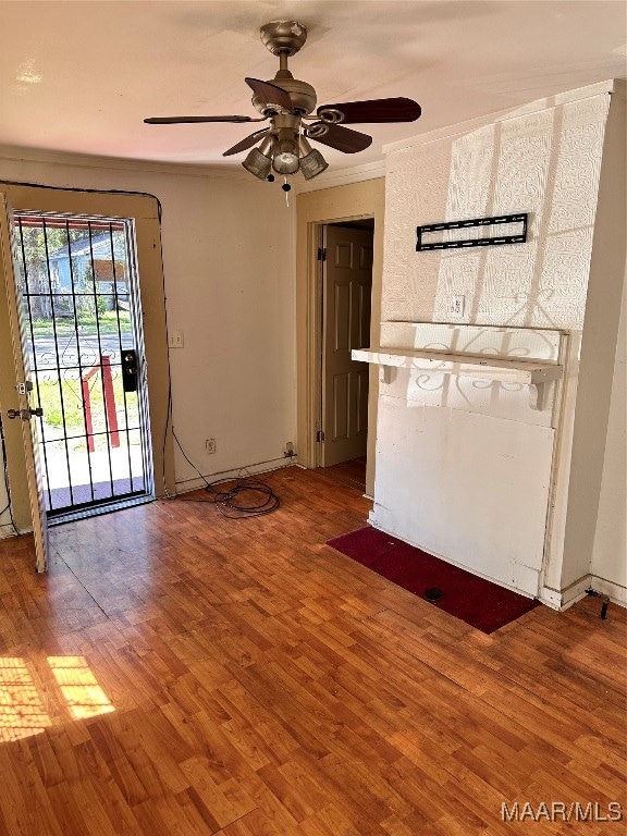 unfurnished living room with crown molding, ceiling fan, and hardwood / wood-style floors