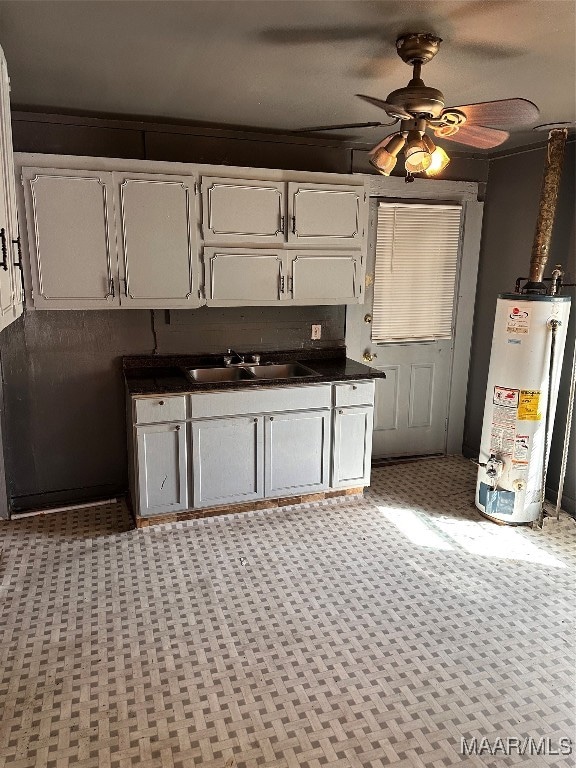 kitchen featuring ceiling fan, sink, gas water heater, ornamental molding, and white cabinetry