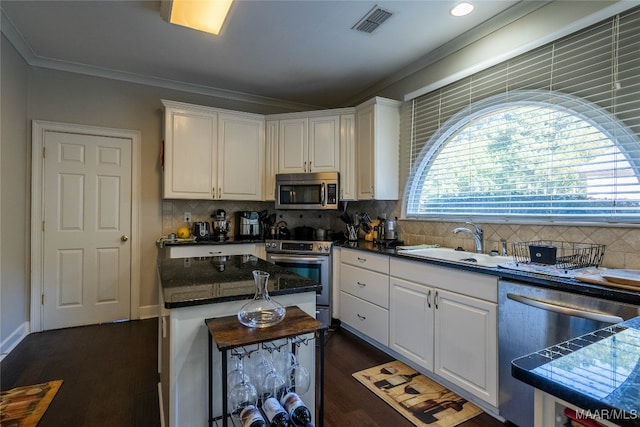 kitchen with sink, dark wood-type flooring, stainless steel appliances, decorative backsplash, and white cabinets