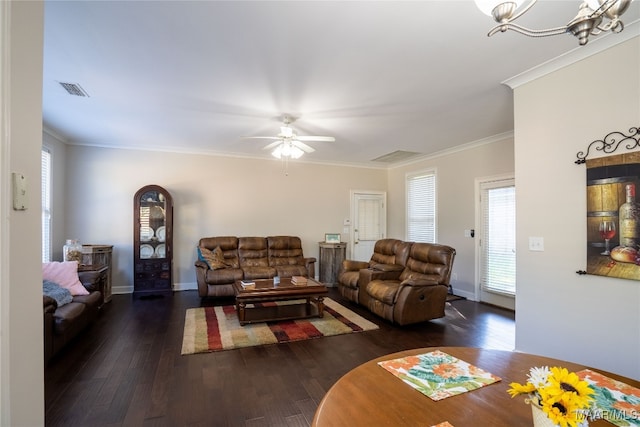 living room featuring ornamental molding, ceiling fan with notable chandelier, a wealth of natural light, and dark wood-type flooring