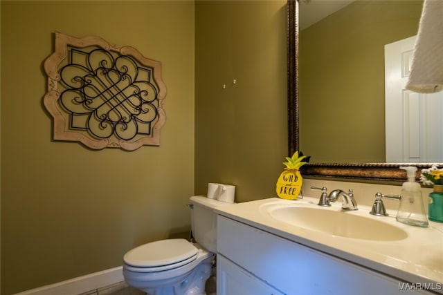 bathroom with tile patterned flooring, vanity, and toilet