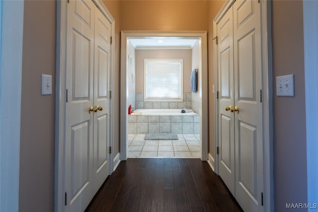 hall with dark wood-type flooring and ornamental molding