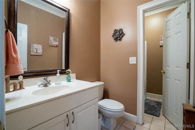 bathroom with toilet, vanity, and tile patterned floors