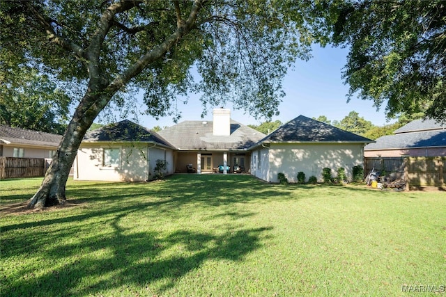 rear view of property with a lawn