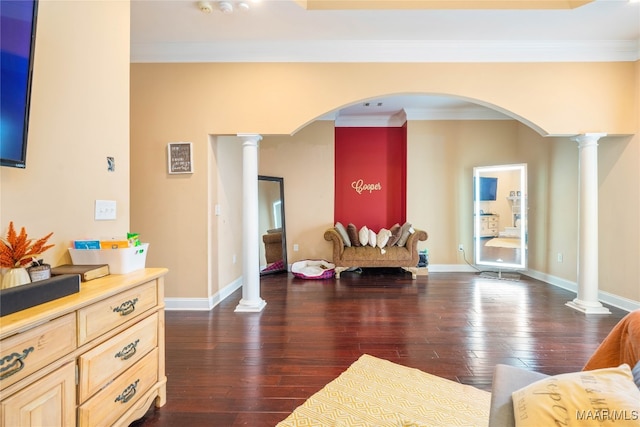 living area with ornate columns, dark hardwood / wood-style floors, and ornamental molding