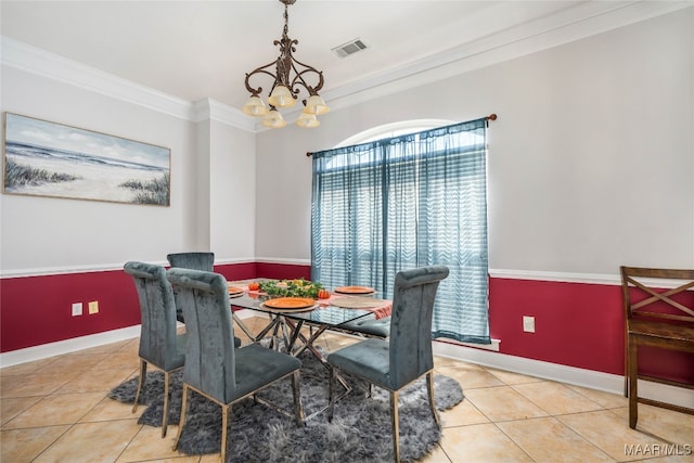 tiled dining room with a notable chandelier and ornamental molding