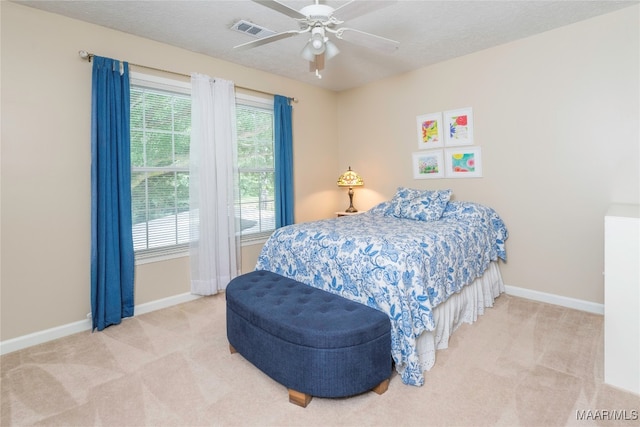 carpeted bedroom featuring a textured ceiling and ceiling fan