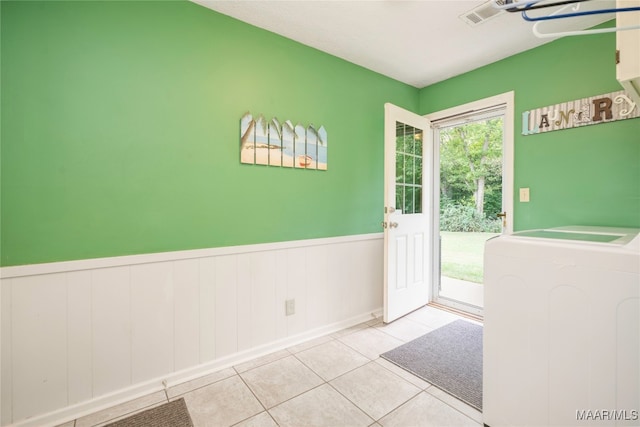 doorway to outside with lofted ceiling, light tile patterned floors, and washer / dryer