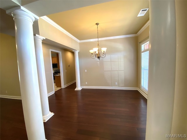 unfurnished dining area featuring dark wood-type flooring, ornate columns, crown molding, and a chandelier