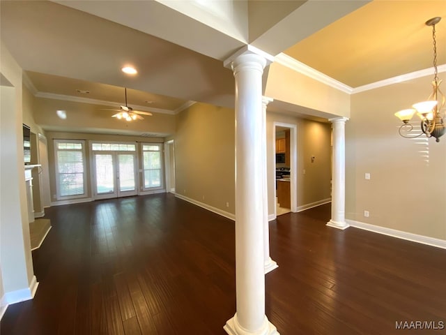 unfurnished living room with ornate columns, ceiling fan with notable chandelier, crown molding, dark wood-type flooring, and french doors