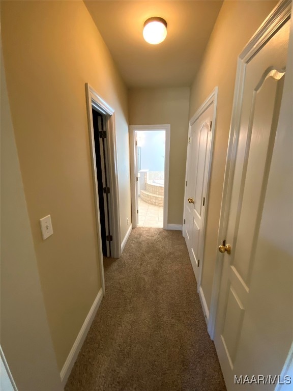 hallway featuring dark carpet