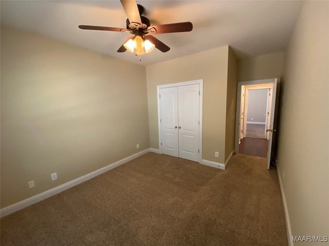 unfurnished bedroom featuring a closet, dark colored carpet, and ceiling fan