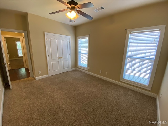 unfurnished bedroom featuring a closet, carpet, and ceiling fan