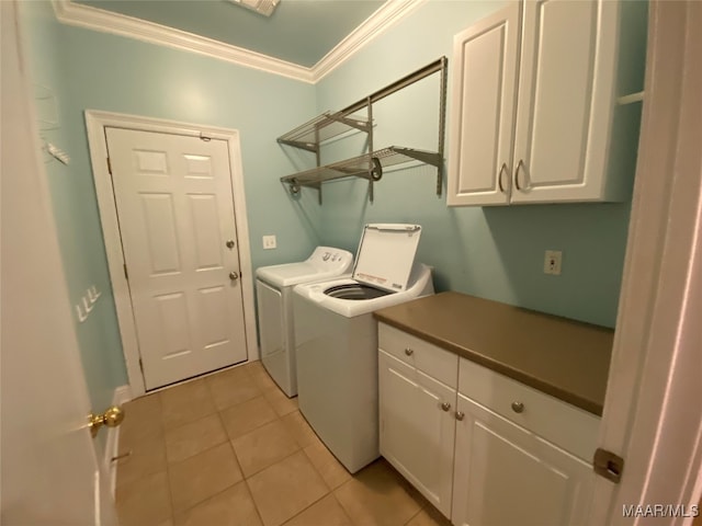 laundry room with light tile patterned floors, cabinets, ornamental molding, and washing machine and clothes dryer