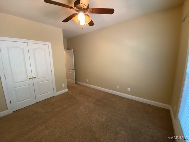 unfurnished bedroom with dark colored carpet, ceiling fan, and a closet