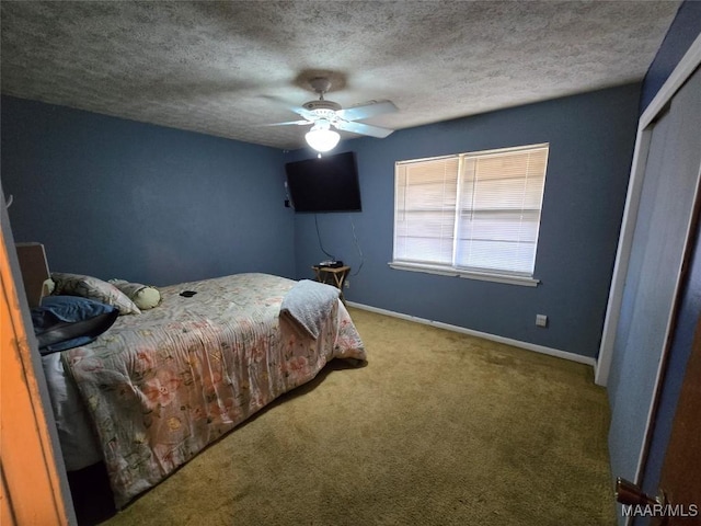 unfurnished bedroom featuring ceiling fan, a closet, carpet floors, and a textured ceiling