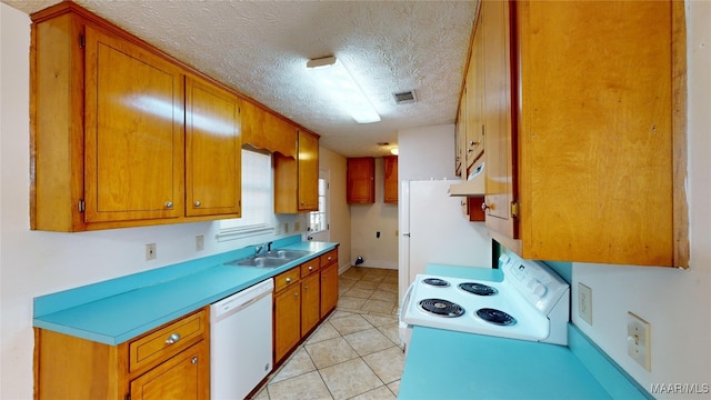 kitchen featuring white appliances, light tile patterned floors, a textured ceiling, and sink