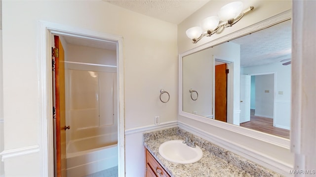 bathroom with vanity, shower / washtub combination, and a textured ceiling