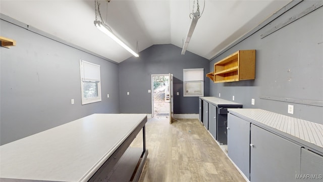 kitchen with light wood-type flooring, vaulted ceiling, and pendant lighting